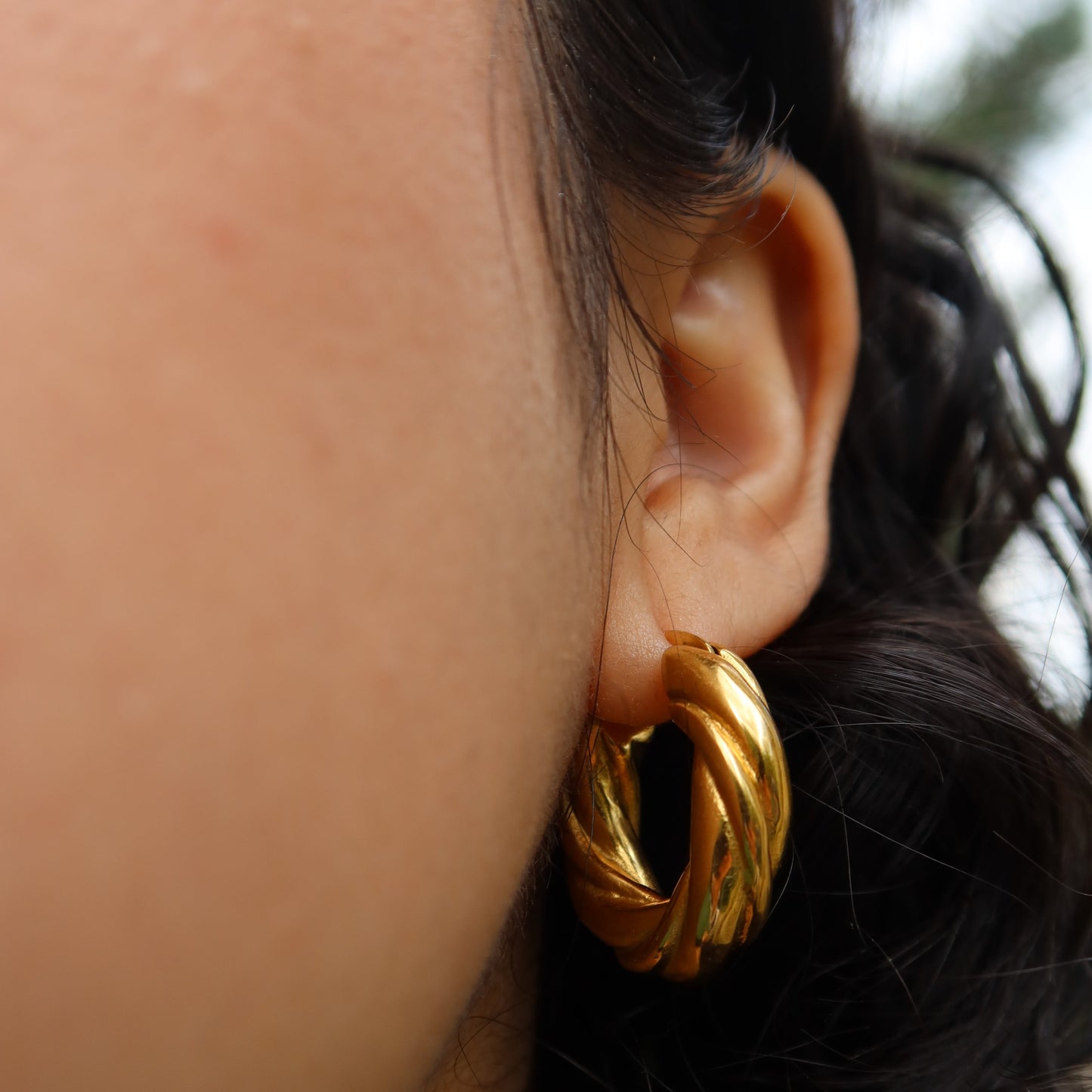 woman wearing gold plated twisted hoop earrings Twisted Hoop Earrings from ShopEternidad.com Affordable 18K Gold Plated Jewelry