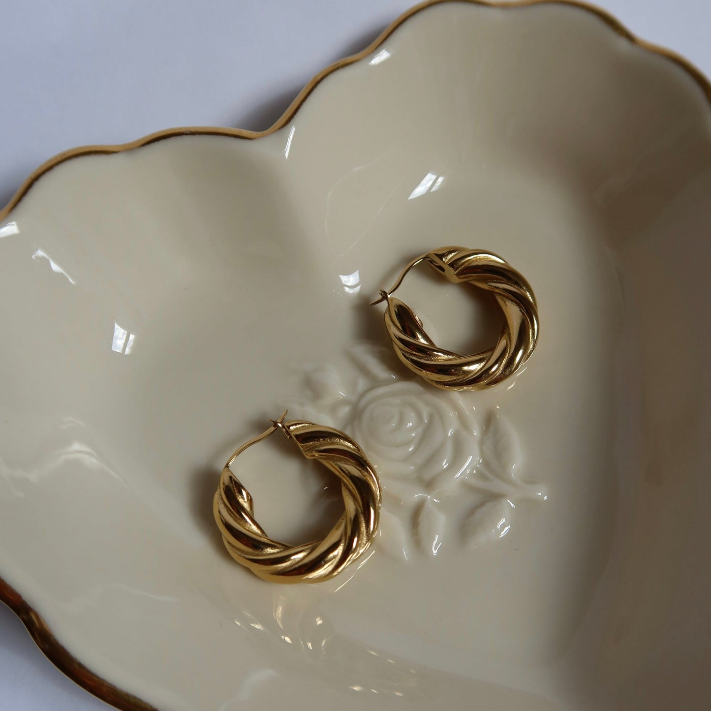 gold plated twisted hoop earrings in heart shaped dish Twisted Hoop Earrings from ShopEternidad.com Affordable 18K Gold Plated Jewelry