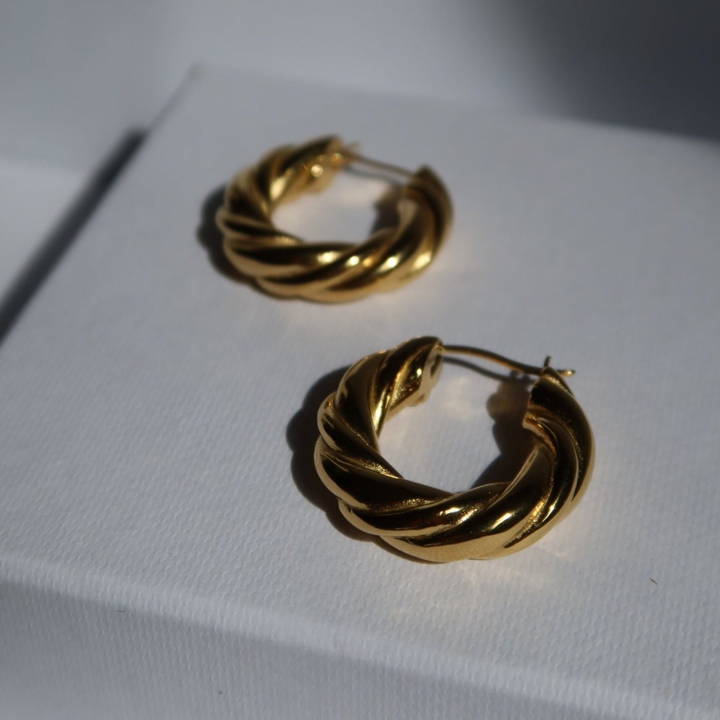 close up photo of gold plated twisted hoop earrings Twisted Hoop Earrings from ShopEternidad.com Affordable 18K Gold Plated Jewelry