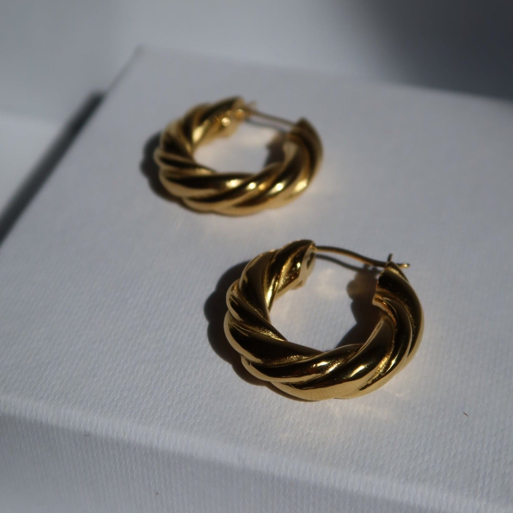 close up photo of gold plated twisted hoop earrings Twisted Hoop Earrings from ShopEternidad.com Affordable 18K Gold Plated Jewelry